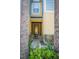 Inviting front entrance with decorative plants leading to a charming, glass-paneled door at 1708 Sunset Wind Loop, Oldsmar, FL 34677