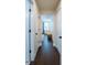 Bright hallway with dark hardwood flooring, white trim, and access to a bedroom with ample natural light at 1708 Sunset Wind Loop, Oldsmar, FL 34677