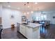 Bright open-concept kitchen with granite island, stainless steel appliances, and modern pendant lights at 1708 Sunset Wind Loop, Oldsmar, FL 34677