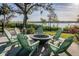 Outdoor seating area with adirondack chairs surrounding fire pit and views of the waterway at 1708 Sunset Wind Loop, Oldsmar, FL 34677