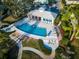 Aerial view of a sparkling blue pool and lounge chairs at Bayside Terrace surrounded by lush landscaping at 1708 Sunset Wind Loop, Oldsmar, FL 34677