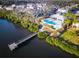 Aerial view of a pool and pier at Bayside Terrace surrounded by lush landscaping and serene water at 1708 Sunset Wind Loop, Oldsmar, FL 34677