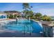 Resort-style community pool with lounge chairs and lush landscaping offers a relaxing oasis for residents at 1708 Sunset Wind Loop, Oldsmar, FL 34677