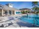 Inviting community pool with a fountain, covered clubhouse, lounge chairs and umbrellas for relaxing in the Florida sunshine at 1708 Sunset Wind Loop, Oldsmar, FL 34677