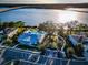 Aerial shot of community pool and clubhouse; mature trees, street parking, with a beautiful water view and bridge in background at 1708 Sunset Wind Loop, Oldsmar, FL 34677