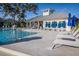 Community pool features a covered clubhouse with lounge chairs and umbrellas for relaxing in the Florida sunshine at 1708 Sunset Wind Loop, Oldsmar, FL 34677