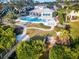 Aerial view of community pool featuring lounge chairs, pristine landscaping, and a charming wooden bridge at 1708 Sunset Wind Loop, Oldsmar, FL 34677