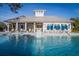 Community pool features a fountain, covered clubhouse, lounge chairs and umbrellas for relaxing in the Florida sunshine at 1708 Sunset Wind Loop, Oldsmar, FL 34677