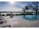 Inviting infinity pool overlooking the waterway with stylish lounge chairs and a charming fire feature for outdoor relaxation at 1708 Sunset Wind Loop, Oldsmar, FL 34677