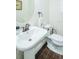 Compact powder room featuring pedestal sink and toilet with wood-look tile floor for a modern design at 1708 Sunset Wind Loop, Oldsmar, FL 34677