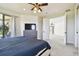 Spacious bedroom with balcony access, TV, and plush carpeting for a serene retreat at 17336 Ballmont Park Dr, Odessa, FL 33556