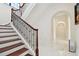 Elegant staircase with decorative wrought iron railing and hardwood treads leading to the upper level at 17336 Ballmont Park Dr, Odessa, FL 33556