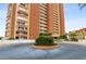 Orange brick high-rise building with circular driveway and landscaping at 17900 Gulf Blvd # 16C, Redington Shores, FL 33708