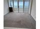 Living area with carpeted floor and access to balcony with ocean view at 17900 Gulf Blvd # 16C, Redington Shores, FL 33708