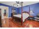 Spacious bedroom with a four poster bed and wood floors at 1801 E Lake Rd # 15C, Palm Harbor, FL 34685