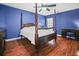 Primary bedroom with wood floors and four-poster bed at 1801 E Lake Rd # 15C, Palm Harbor, FL 34685