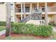 Condo building exterior with stairs and landscaping at 1801 E Lake Rd # 15C, Palm Harbor, FL 34685