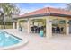 Relaxing poolside pavilion with tables, chairs, and a kitchen at 1801 E Lake Rd # 15C, Palm Harbor, FL 34685