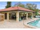 Covered poolside patio with tables, chairs and kitchen area at 1801 E Lake Rd # 15C, Palm Harbor, FL 34685