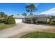 White brick ranch home with circular driveway and mature landscaping at 2389 Sarazen Dr, Dunedin, FL 34698