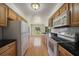 Galley kitchen with wood cabinets and modern appliances at 2389 Sarazen Dr, Dunedin, FL 34698