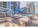 Inviting pool area with lounge chairs and blue umbrellas at 301 1St S St # 1404, St Petersburg, FL 33701