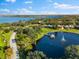 Aerial view of Cobb's Landing community with lake, gazebo, and lush landscaping at 3312 Cobbs Ct, Palm Harbor, FL 34684