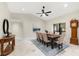 Bright dining room with a long table, grandfather clock, and large windows at 3312 Cobbs Ct, Palm Harbor, FL 34684