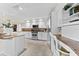 Bright kitchen featuring white cabinets, granite counters, and a built-in desk at 3312 Cobbs Ct, Palm Harbor, FL 34684