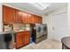 Laundry room with washer, dryer and wood cabinets at 3312 Cobbs Ct, Palm Harbor, FL 34684