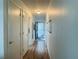 Long hallway with light wood flooring and doors at 400 Glennes Ln # 108, Dunedin, FL 34698