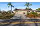 Street view of a single story home featuring a 2-car garage, palm trees, meticulous landscaping and a concrete driveway at 4001 Harbor Hills Dr, Largo, FL 33770