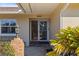 Inviting front entrance featuring a decorative light, well-maintained landscaping, and an elegant glass front door at 4001 Harbor Hills Dr, Largo, FL 33770