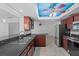 Modern kitchen featuring stainless steel appliances, granite countertops, and coffered ceiling with ceiling fan at 4001 Harbor Hills Dr, Largo, FL 33770