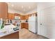 Well-equipped kitchen featuring light wood cabinets, white appliances, and laminate flooring at 4079 Overture Cir # 346, Bradenton, FL 34209