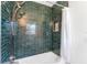 Updated bathroom with dark green tile shower and white bathtub at 4400 Carson Ne St, St Petersburg, FL 33703