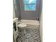 Updated bathroom features gray tile, a new tub, and patterned flooring at 4400 Carson Ne St, St Petersburg, FL 33703