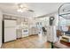 Kitchen with white appliances, light beige cabinets and tile floors at 5157 School Rd, New Port Richey, FL 34653