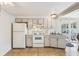 Kitchen with white appliances, light beige cabinets, and tile floors at 5157 School Rd, New Port Richey, FL 34653