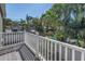 Deck with white railings overlooking lush tropical foliage and a glimpse of the inviting pool at 540 Villagrande S Ave, St Petersburg, FL 33707