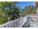 This is a covered deck with a white railing and tropical landscaping at 540 Villagrande S Ave, St Petersburg, FL 33707