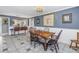 Blue dining room featuring wooden chairs, beautiful artwork, and white wainscotting at 540 Villagrande S Ave, St Petersburg, FL 33707