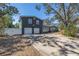 Exterior view featuring a spacious garage, white fence, and a well-maintained lawn at 540 Villagrande S Ave, St Petersburg, FL 33707