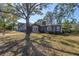 Beautiful home exterior featuring mature trees, a well-manicured lawn, and charming architectural details at 540 Villagrande S Ave, St Petersburg, FL 33707