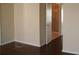 Neutral bedroom with hardwood floors, baseboard, and a view into the bathroom at 5532 War Admiral Dr, Wesley Chapel, FL 33544