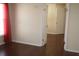 Bright bedroom featuring wood-look flooring, neutral walls, and a window with translucent red curtains at 5532 War Admiral Dr, Wesley Chapel, FL 33544