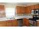 Well-lit kitchen with stainless steel appliances, wooden cabinets, and decorative backsplash at 5532 War Admiral Dr, Wesley Chapel, FL 33544