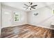 Bright living room with wood floors and modern ceiling fan, featuring a charming white front door and window at 5644 Missouri Ave, New Port Richey, FL 34652