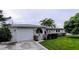 Ranch-style home with a green exterior, attached garage, and well-maintained lawn at 568 Seacrest Dr, Largo, FL 33771