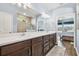 Modern bathroom with double sinks, a large mirror and access to the bedroom at 6230 Plover Meadow St, Lithia, FL 33547